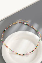 Alt Tag: multicolored bead necklace with freshwater pearls featuring crystal beads and gold clasp on white plate
