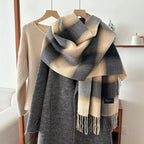 Alt Tag: plaid fringe scarf in beige and navy plaid with tassel fringe, draped over gray coat on hanger, polyester imported