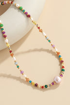 Alt Tag: multicolored bead necklace with freshwater pearls featuring crystal beads and pearl pendant on beige background