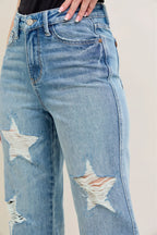 Close-up of plus size 90s high waist jeans with star-shaped destroy details and a trendy retro design.