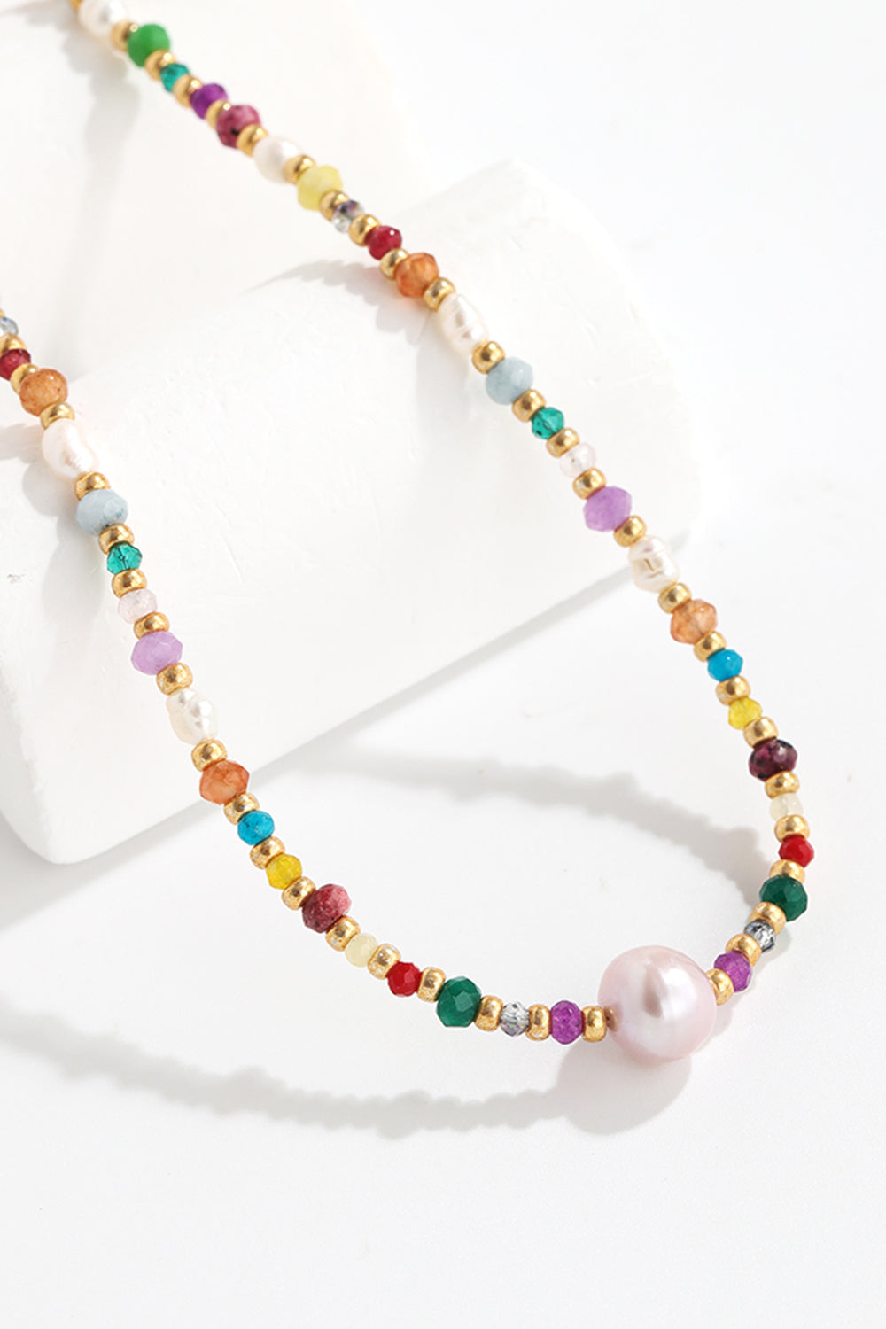 Alt Tag: multicolored bead necklace with freshwater pearls featuring crystal and bead accents, colorful strand with pearl pendant on white display